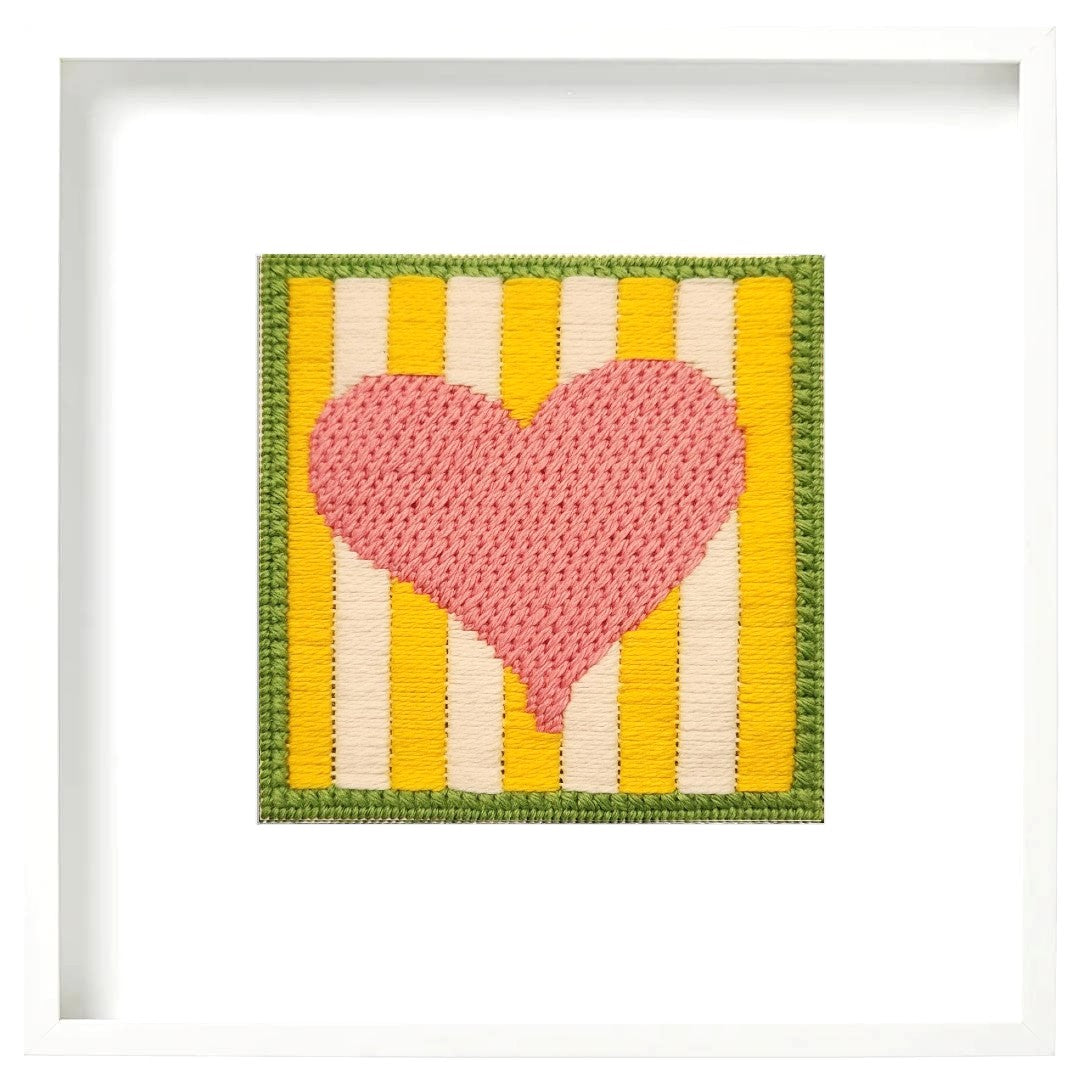 Crocheted heart with yellow and white striped background