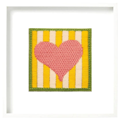 Crocheted heart with yellow and white striped background
