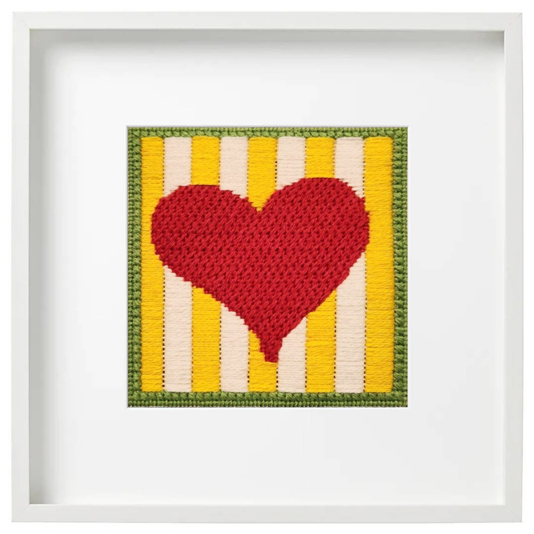 Framed needlepoint heart with yellow and white striped background