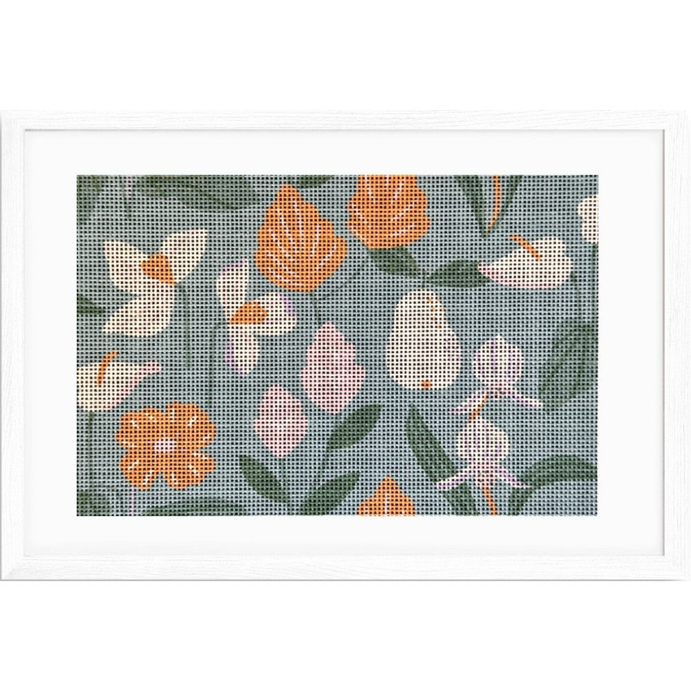 Floral patterned needlepoint design with orange and white flowers on a blue background