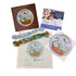 Needlepoint kit with completed sample, thread, and instructions on a white background