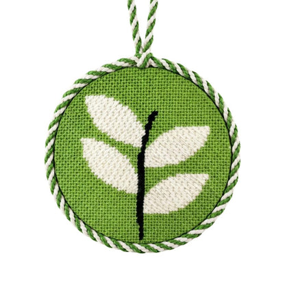 Decorative needlepoint ornament with leaf design on a green background