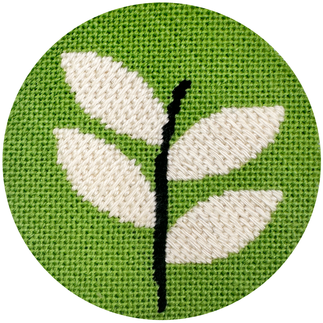 needlepoint round design ofwhite leaves on green background