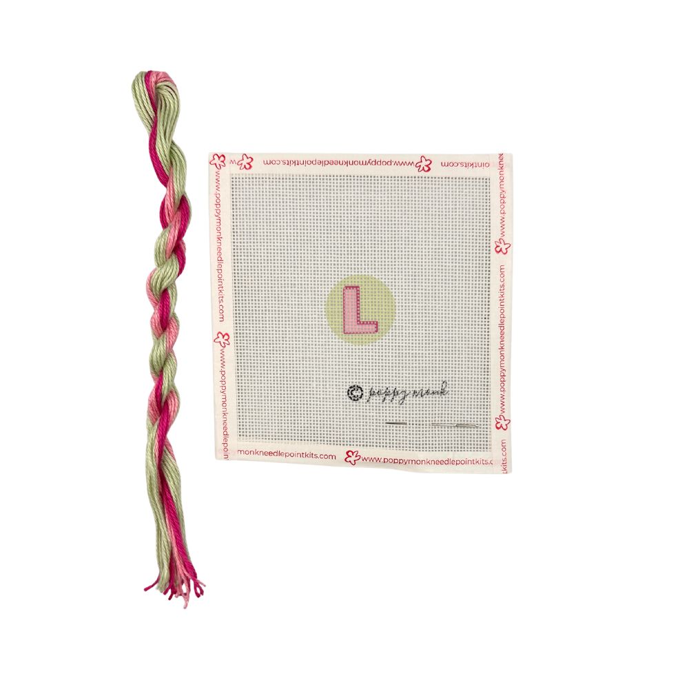 Braided pink and green yarn with a cross-stitching pattern on a white background