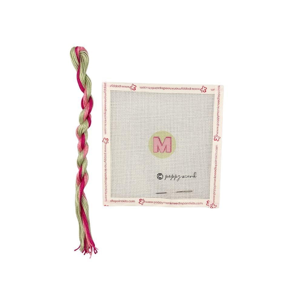 Braided pink and green toy with a branded card on a white background