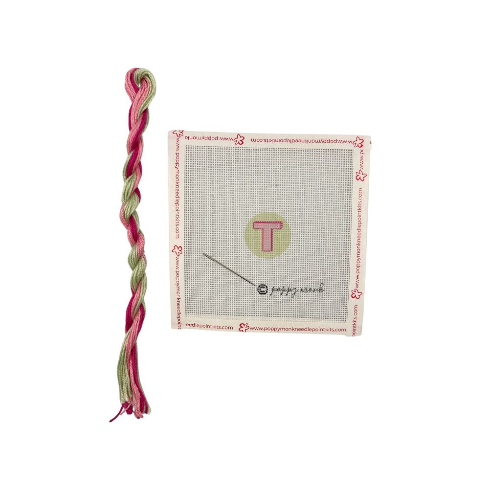Braided pink and green yarn with a package on a white background