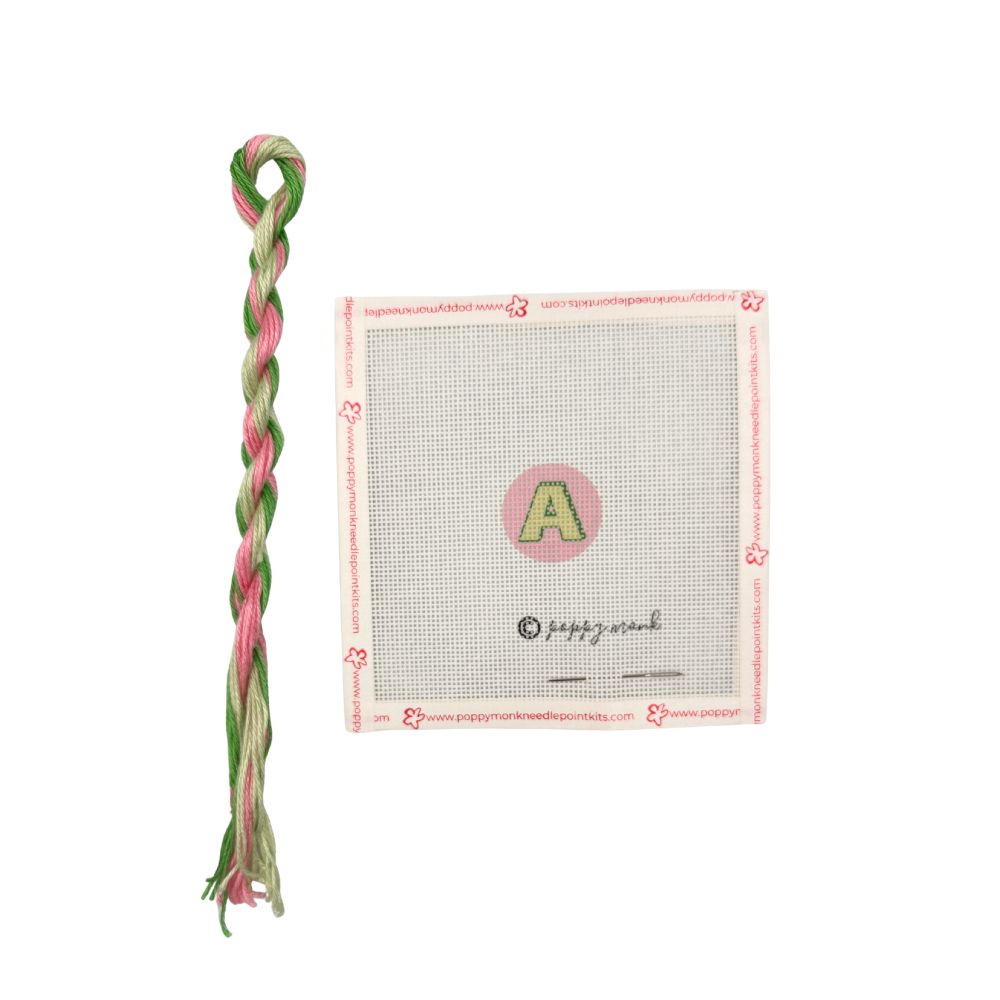 Green and pink thread with a branded card on a white background