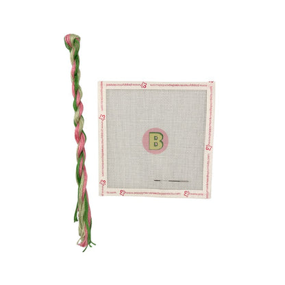 Braided pink and green thread with a canvas panel featuring a letter &