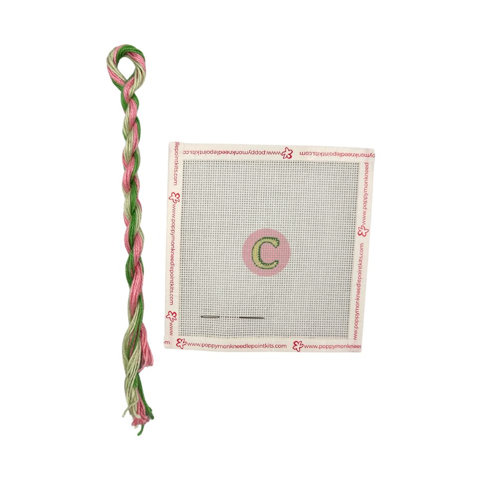 Green and pink braided thread with a packaging label on a white background