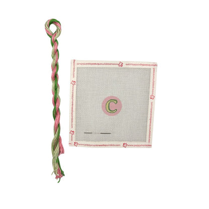 Green and pink braided thread with a packaging label on a white background