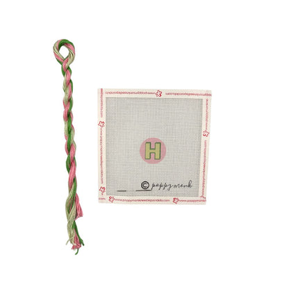 pink and green thread with H canvas