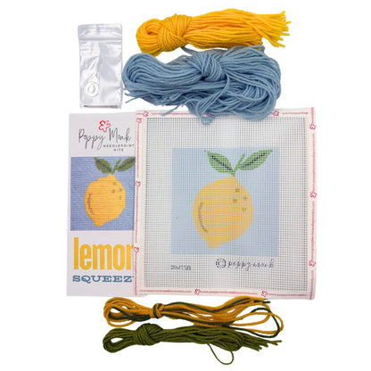 Needlepoint kit with yarn and pattern card featuring a lemon design on a white background