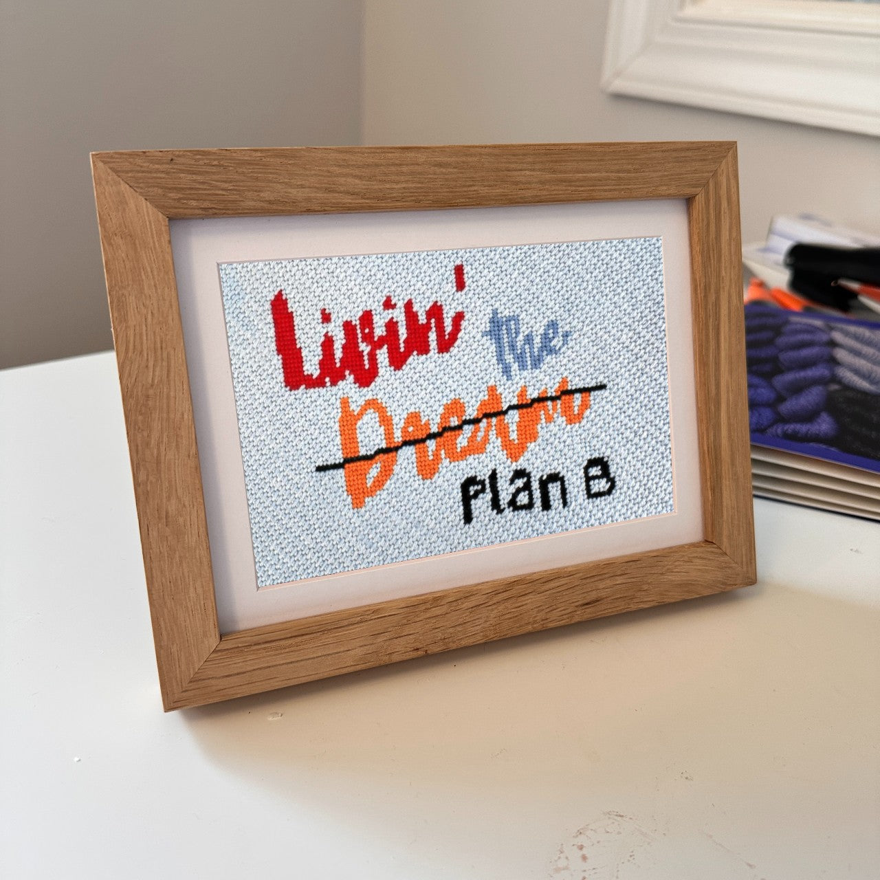 Livin the Dream needlepoint in an oak frame
