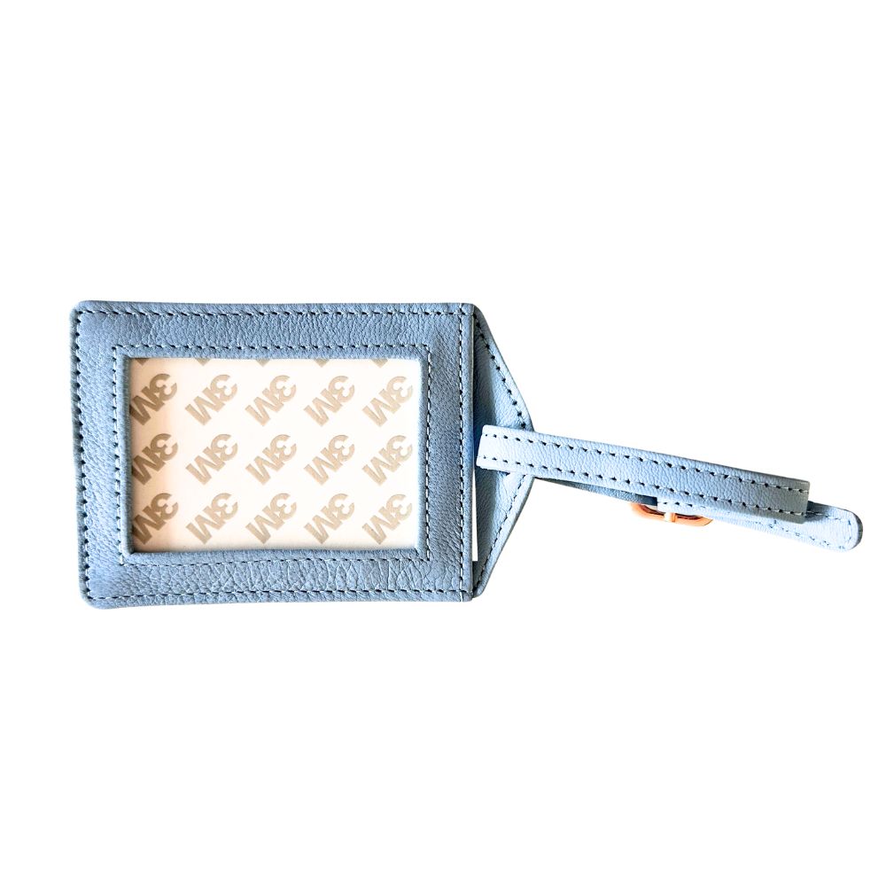 Blue leather luggage tag with a beige label on a white background