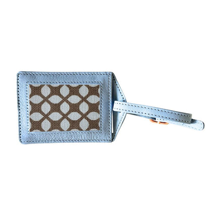 Light blue luggage tag with a patterned label on a white background