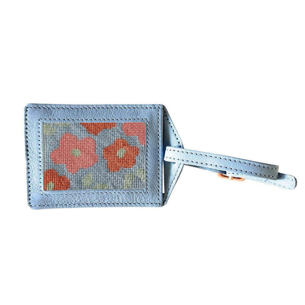 Luggage tag with floral design on a light blue background