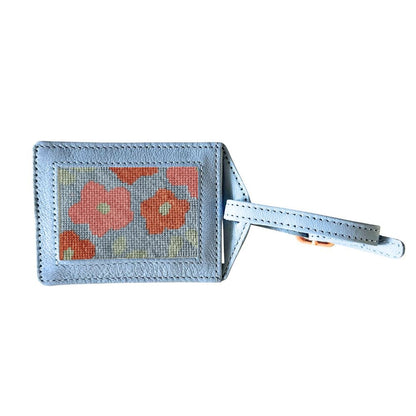 Luggage tag with floral design on a light blue background