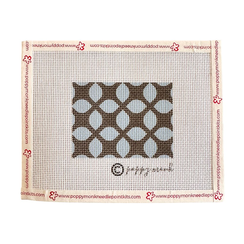 Patterned needlepoint canvas with geometric design on a white background, featuring Poppy Monk branding.