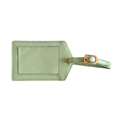 Green leather luggage tag with a gold buckle on a white background