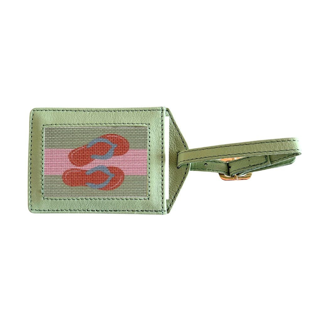 Green luggage tag with pink and red design on a white background