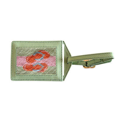 Green luggage tag with a flip flops design on a white background