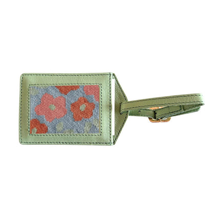 Green luggage tag with floral design on a white background