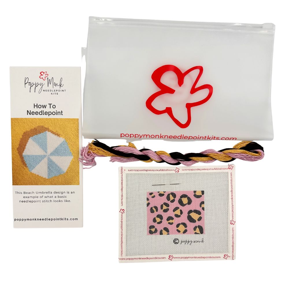 Poppy Monk needlepoint kit with yarn, canvas, and instructions on a white background