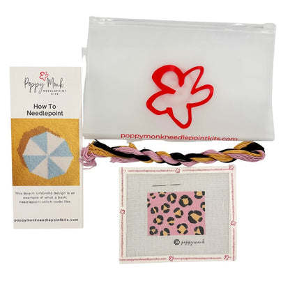 Poppy Monk needlepoint kit with yarn, canvas, and instructions on a white background