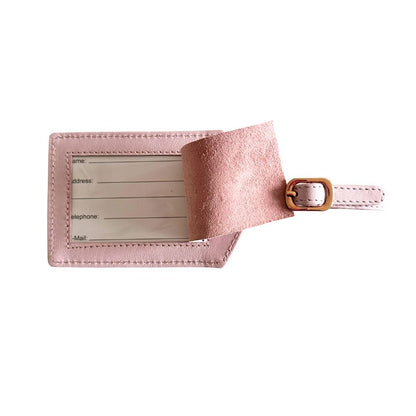 Pink leather luggage tag with a gold buckle on a white background