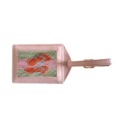 Luggage tag with a needlepoint design of a flamingo on a pink background
