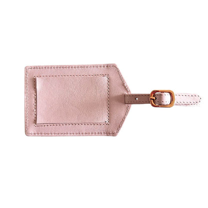 Pink leather luggage tag with a gold buckle on a white background