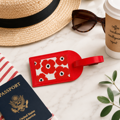 Luggage tag with poppies design shown with travel items