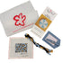 A Poppy Monk needlepoint kit laid out on a white background, including a translucent white pouch with a red flower outline and website print, a printed how-to card, a blue leatherette strap with a metal ring, a square canvas with a leopard-print sample, and a braided cord in blue, tan, black, and white.