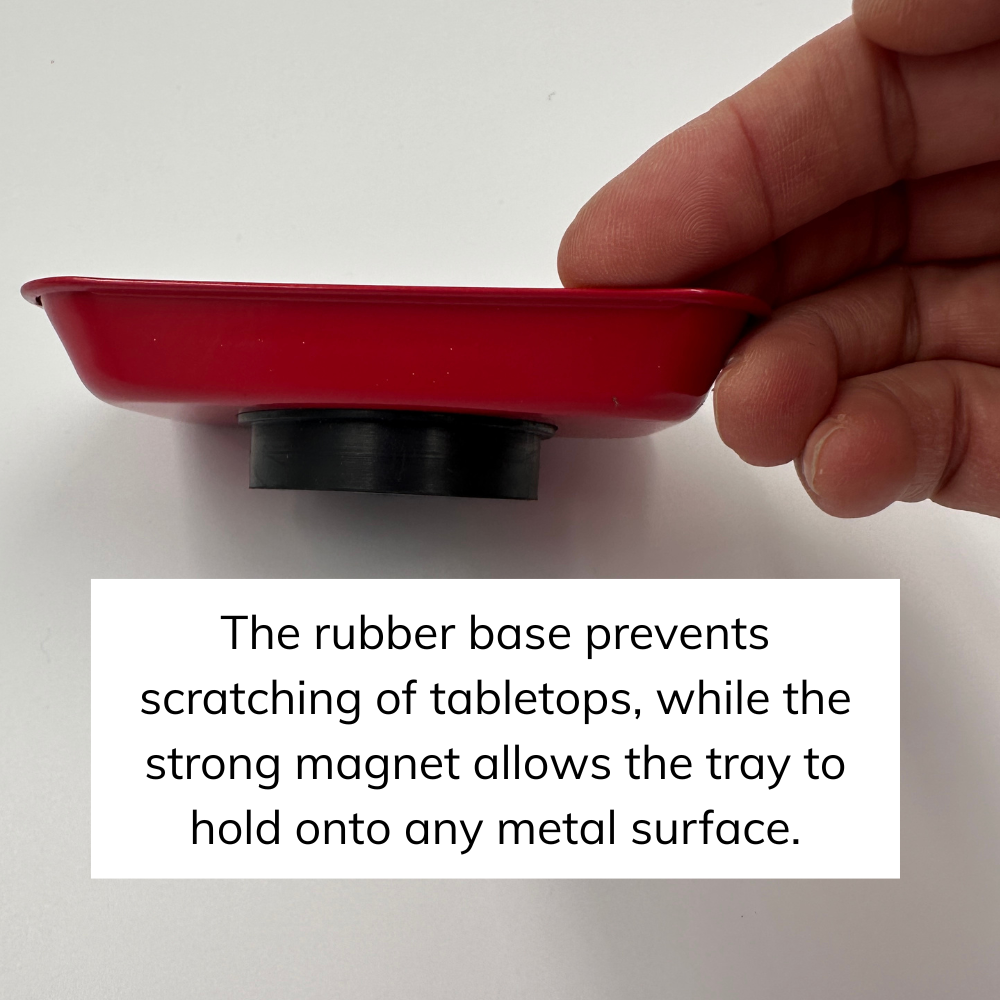 Red tray with a black magnet held by a hand on a white background