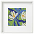 Framed needlepoint artwork of white magnolia flowers with blue leaves on a green background