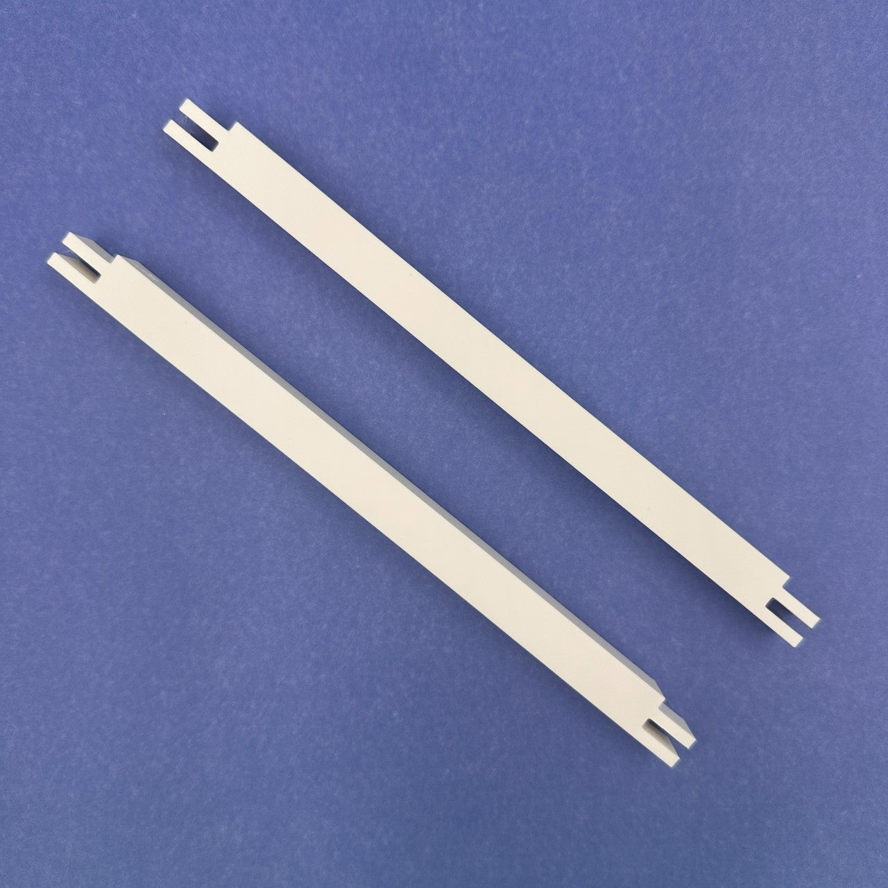 Two white plastic stretcher bars on a blue background