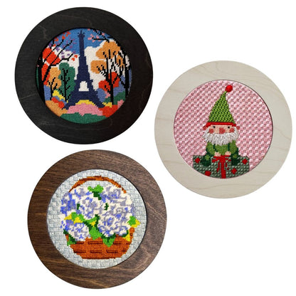 Three round needlepoint pieces with different designs on a white background.