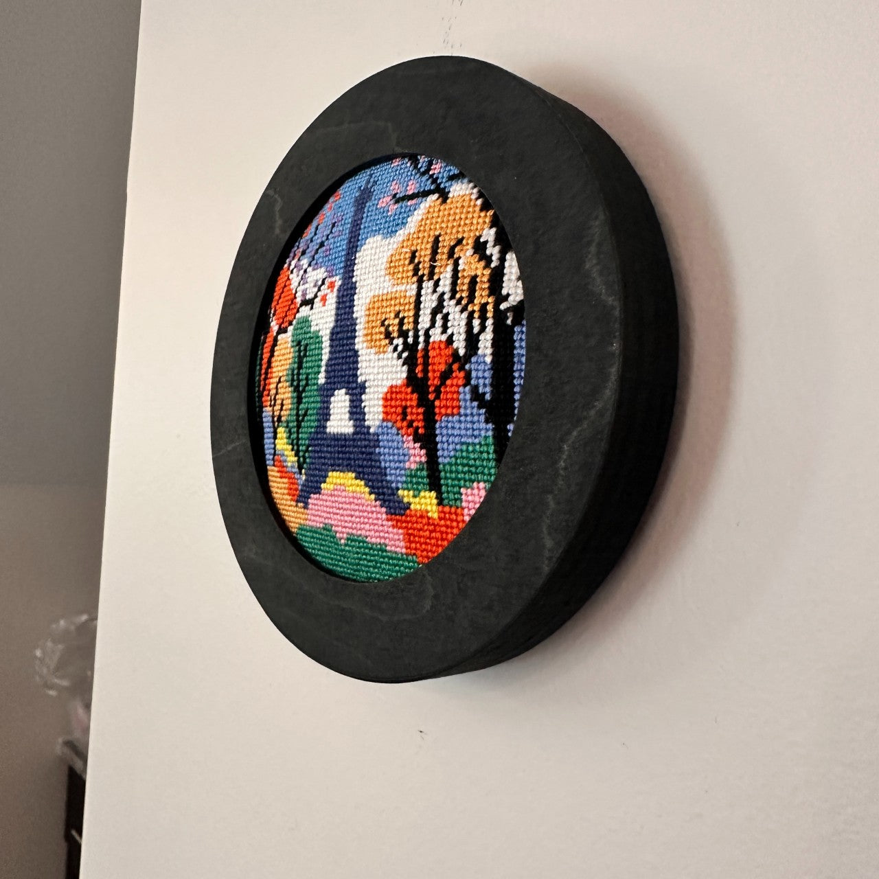 side view needlepoint in a round frame
