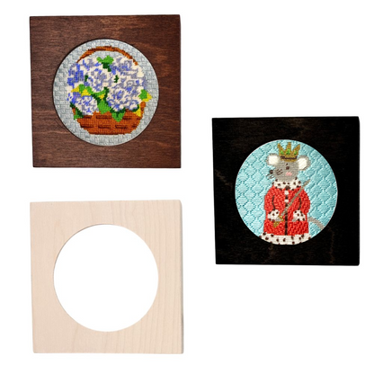 Three framed needlepoint pieces on a white background