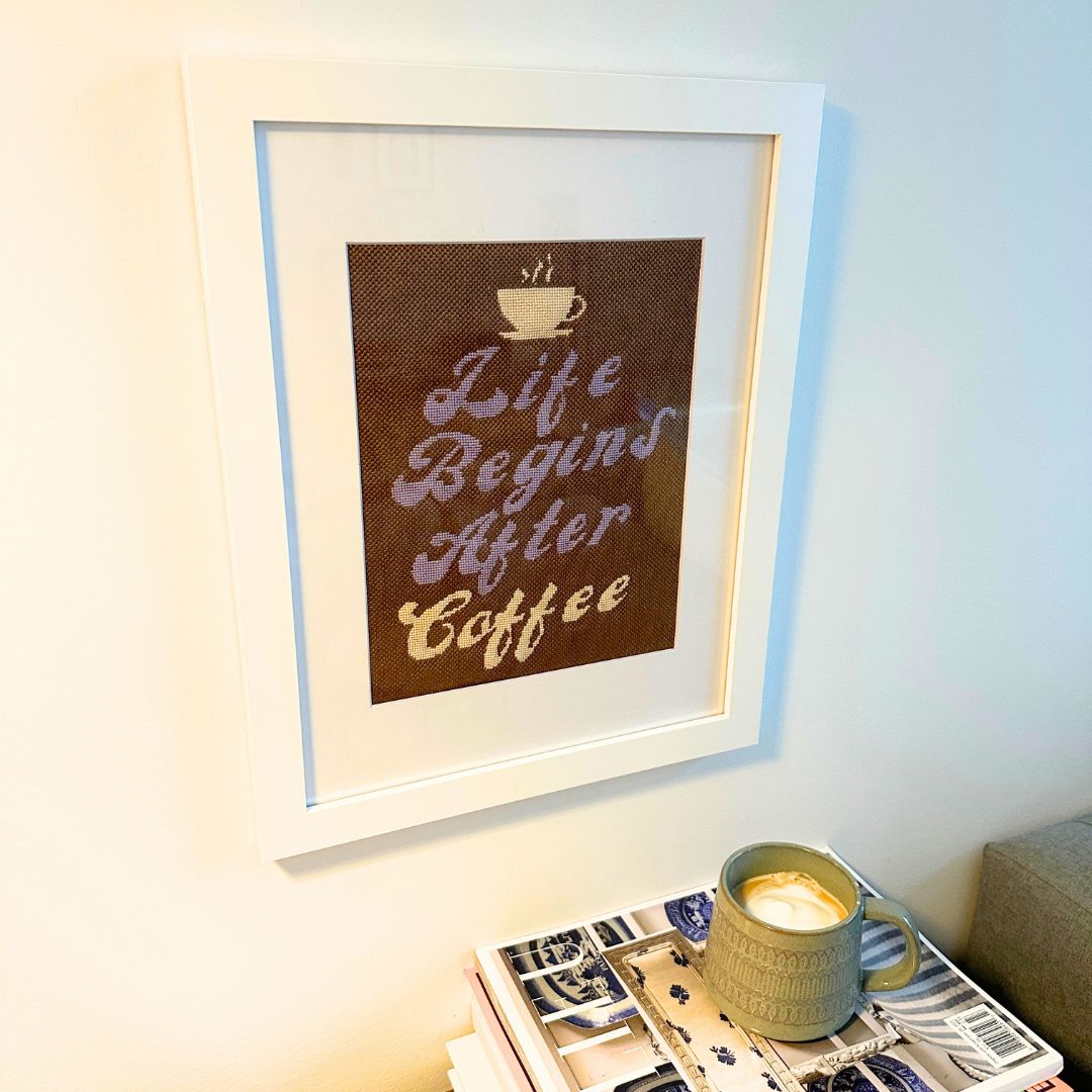 An 8&quot; x 10&quot; needlepoint Life Begins After Coffee shown in a white frame