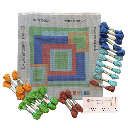 needlepoint pillow kit with abstract design and skeins of wool