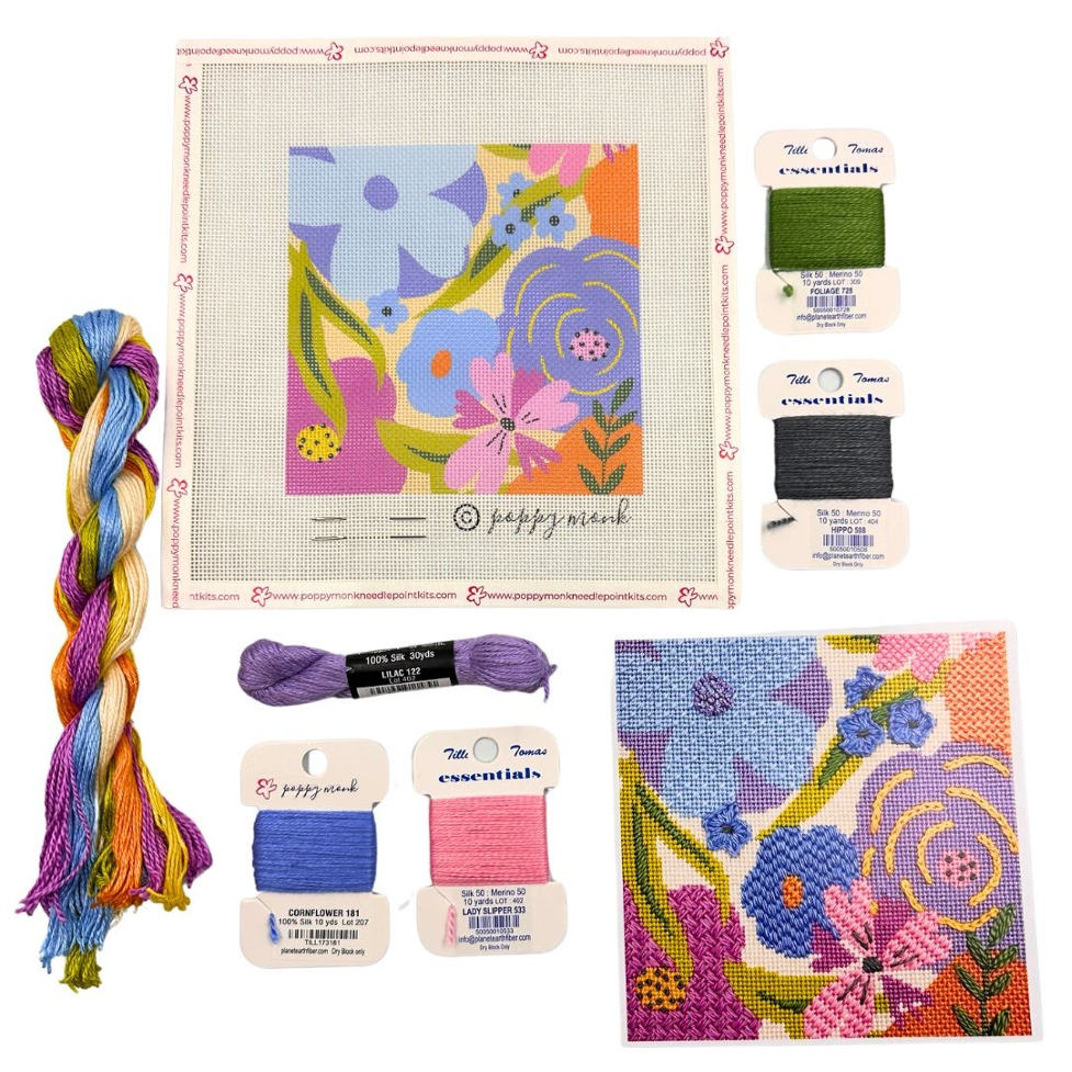 Cross stitch kit with colorful thread and pattern on a white background