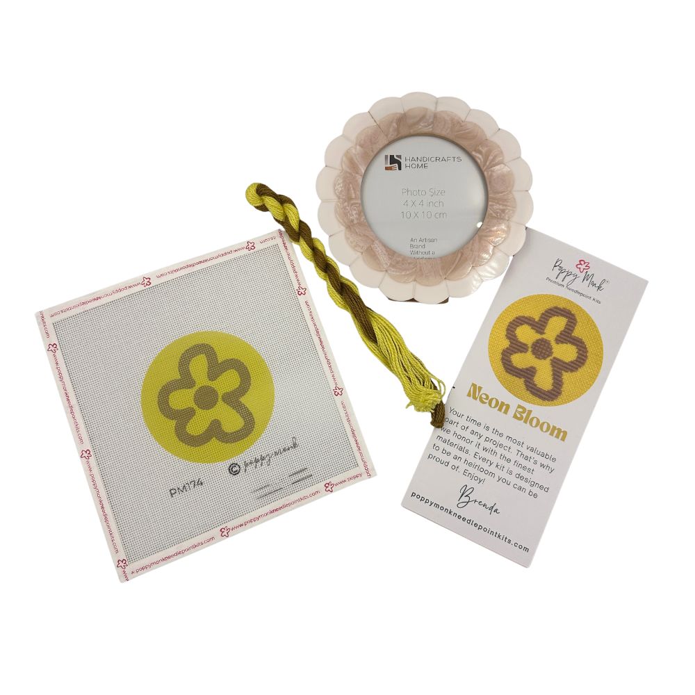 A needlepoint kit with modern floral motif and a scalloped frame