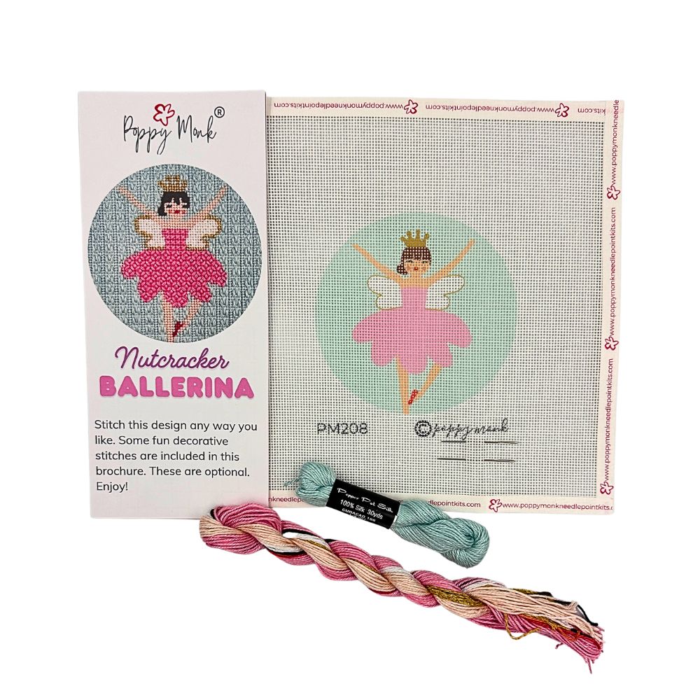 Needlepoint kit with ballerina design, thread, and packaging on a white background