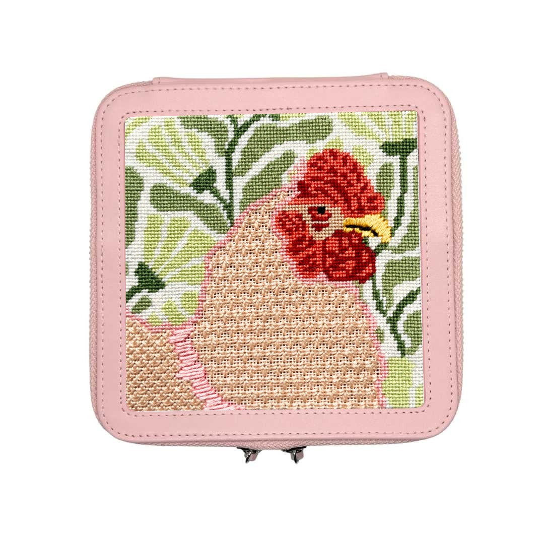 Small pink case with a needlepoint hen design on a white background