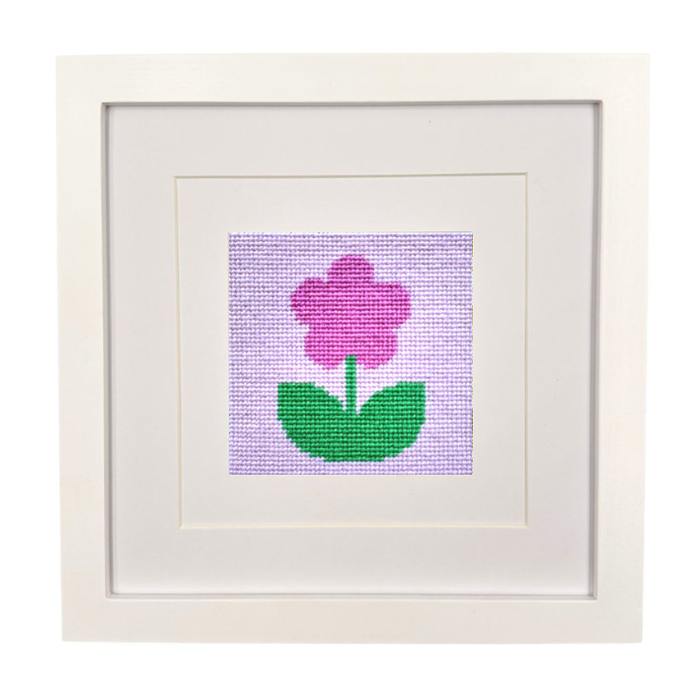 Framed needlepoint flower design on a white background