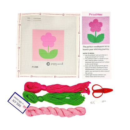 A needlepoint kit of a flower with threads and scissors