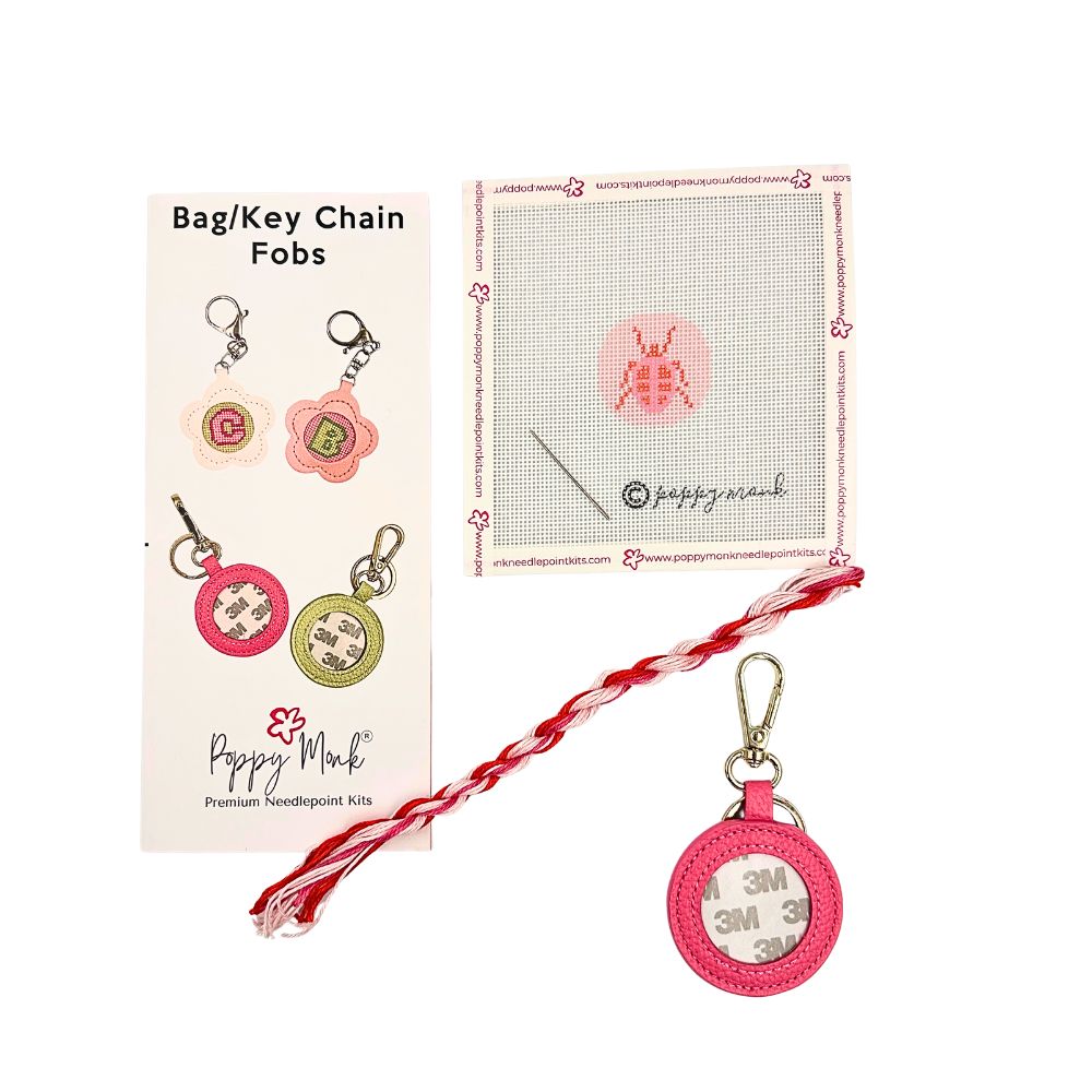 A needlepoint kit with a small round pink beetle design with fob hardware.