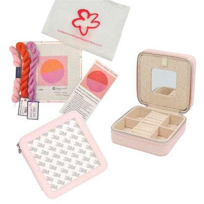 A pink jewelry box with a circle orange and pink needlepoint design