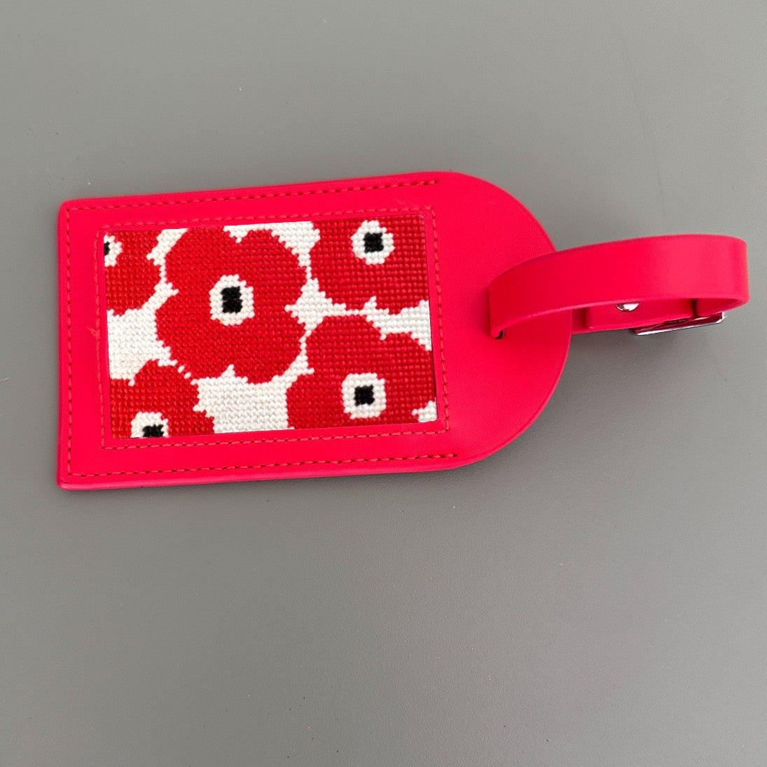 red luggage tag with poppies design